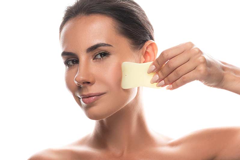 How To Use A Gua Sha Scraper Or Rose Quartz Roller On The Face